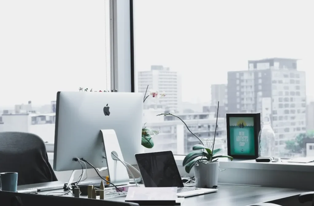 Sleek workspace with a large desktop monitor and laptop.
