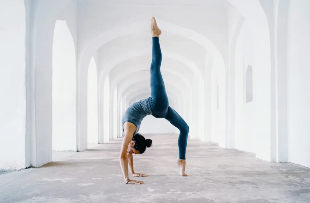 Tai Chi handstand in a serene, white-arched space.
