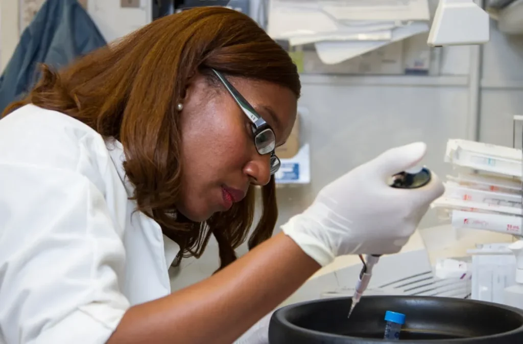 Scientist using a pipette in lab testing.