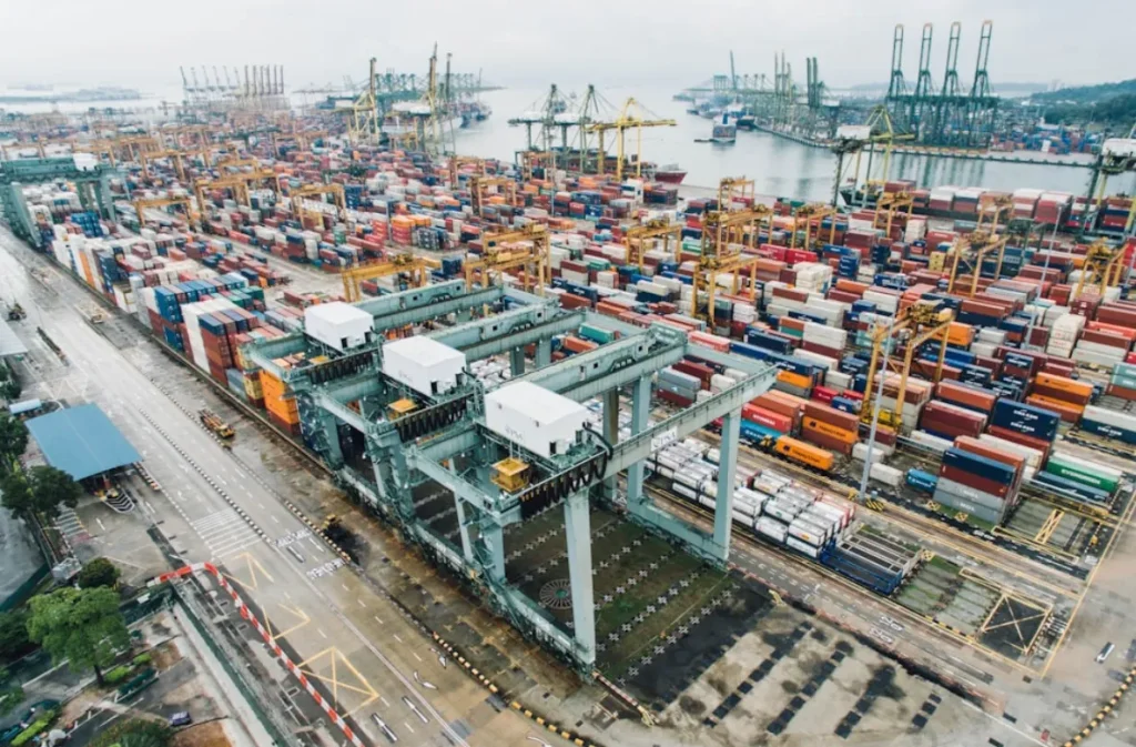 Cranes handling hydrogen cargo containers at a busy port.