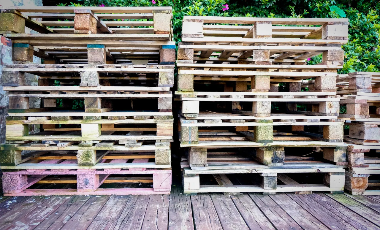 Stacked wooden pallets in an outdoor setting.