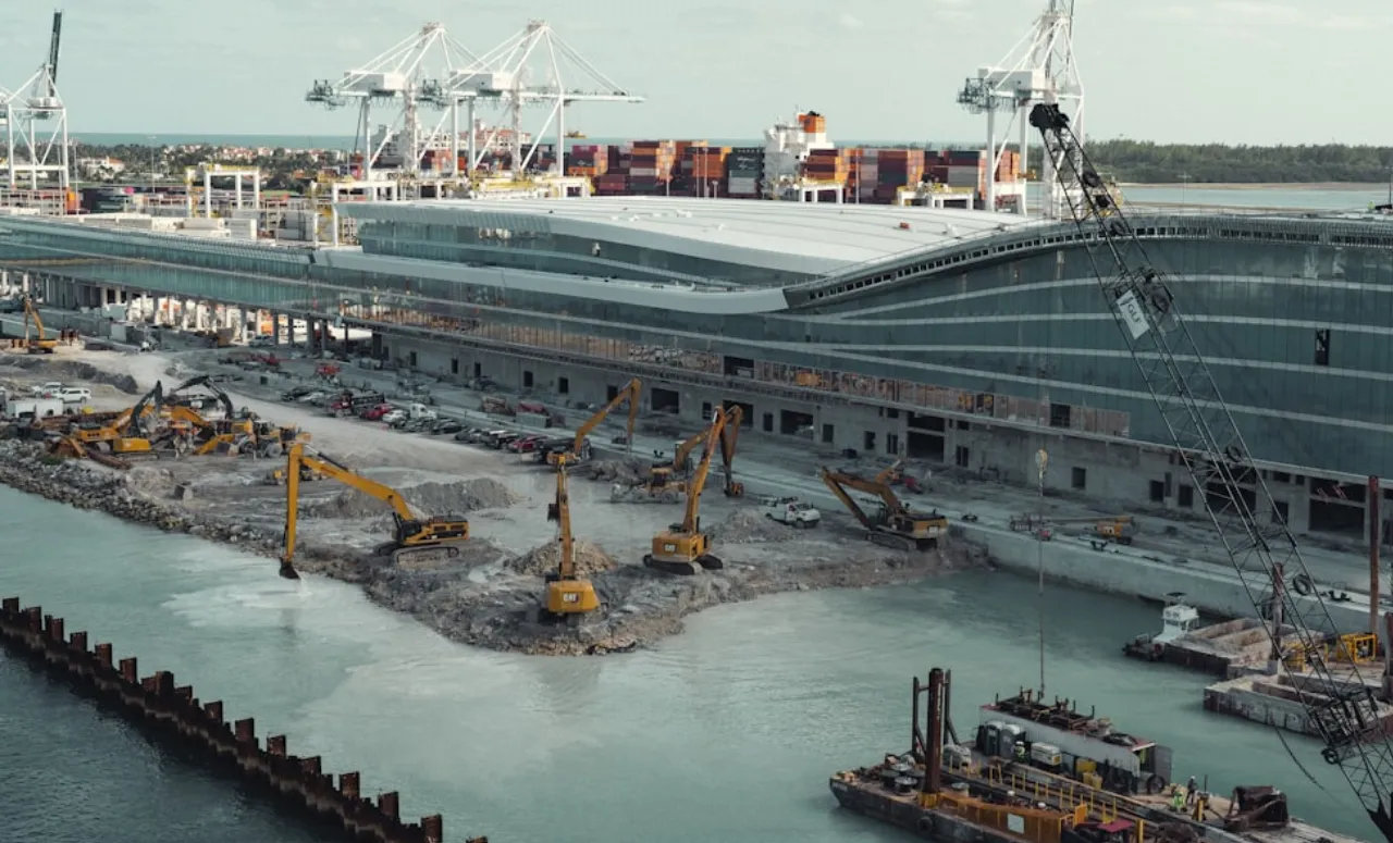 A modern port under construction with shipping cranes and equipment.