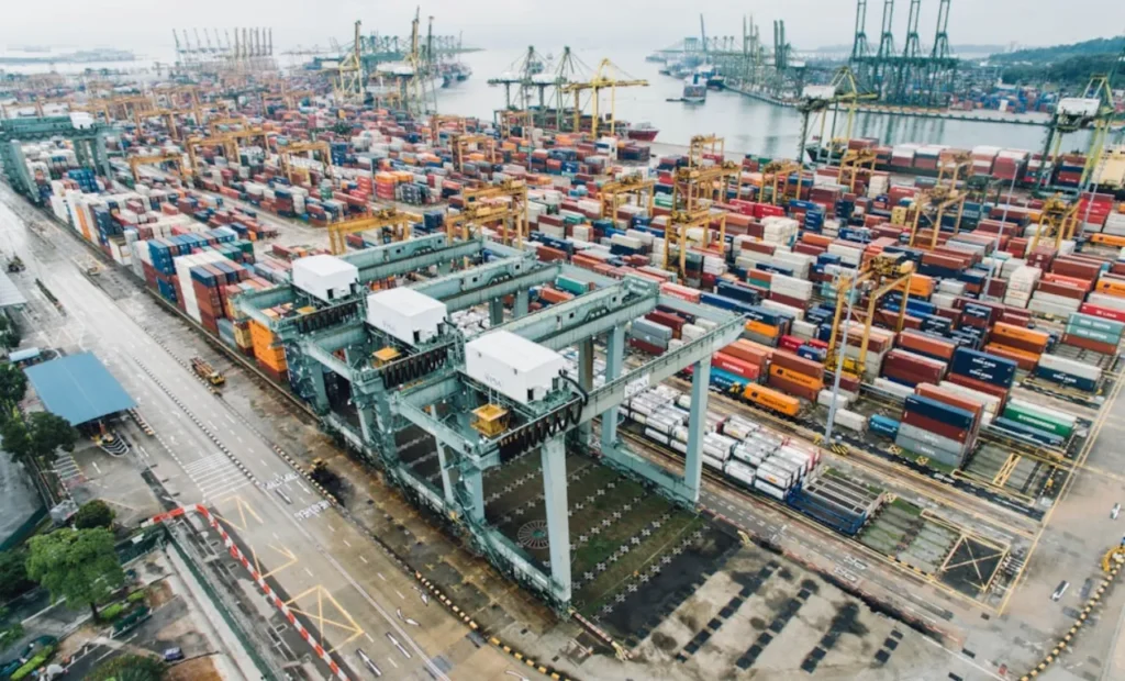 Aerial view of a container terminal with organized cargo and cranes.